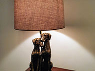 Detail of table lamp with stand featuring two sitting dogs